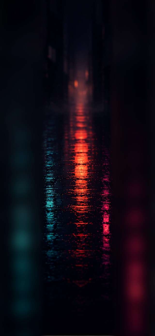 Abstract reflections of orange, teal, and magenta city lights on dark rain-soaked pavement at night